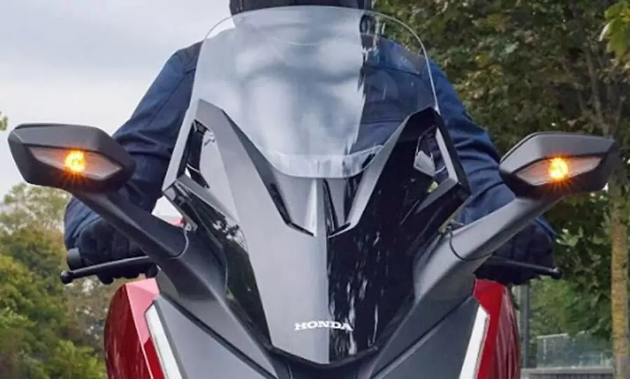 Desain spion elegan yang terpasang kokoh pada bodi depan dan terintegrasi langsung dengan lampu sein LED, menciptakan tampilan aerodinamis sekaligus modern.